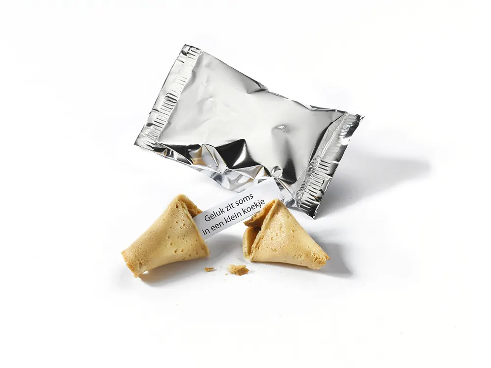 Glückskeks Smart in silberner Standardfolie neben einem aufgebrochenen Keks mit Glückszettel